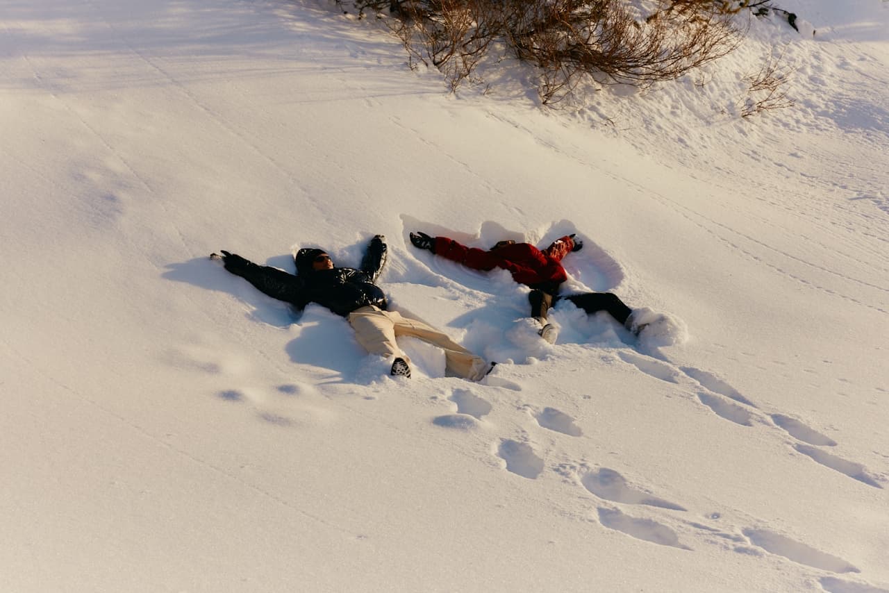 Zwei Erwachsene liegen im Schnee