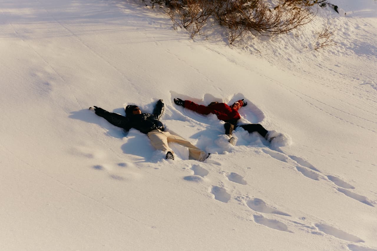 Zwei Erwachsene liegen im Schnee